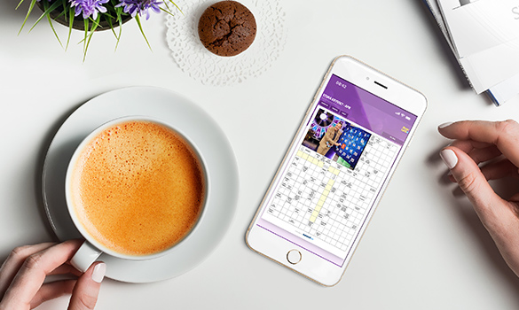 BingoLottos korsord i en mobil, bredvid en kopp kaffe och muffin
