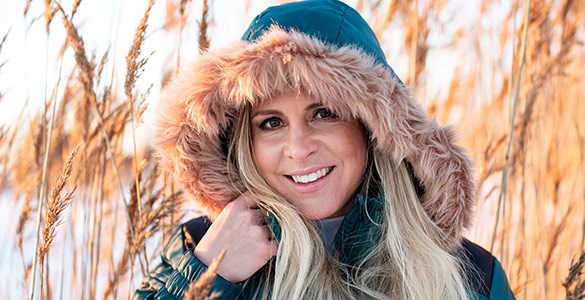 Lisa Miskovsky står utomhus i vinterjacka med vass i bakgrunden