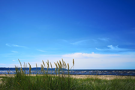 Sandstrand, blå himmel och hav en sommardag