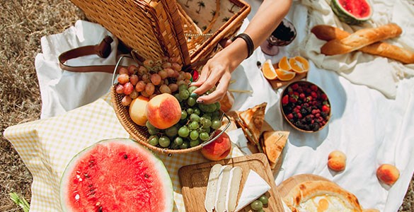 Picknickfilt med baguetter, vattenmelon och bär