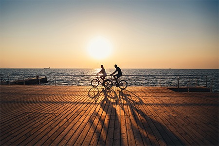 Par som cyklar vid vattnet