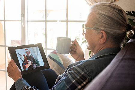 En äldre dam firar jul genom sin iPad