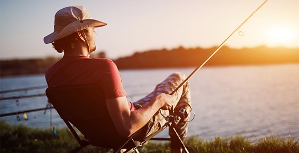 Person som fiskar med fiskespö i solnedgång