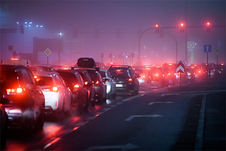 Bilkö i stadsmiljö en dimmig kväll
