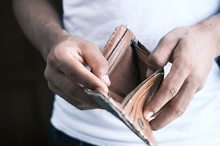 En person visar upp sin tomma plånbok