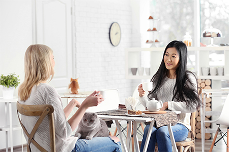 Två tjejer som fikar på kattcafé