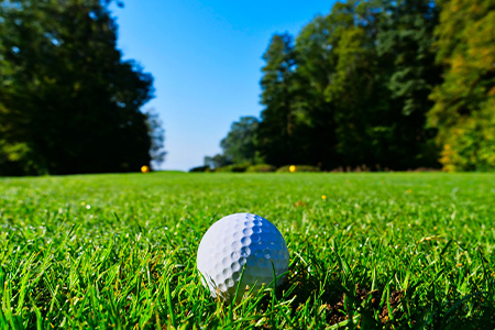 Golfboll på golfbana en solig dag