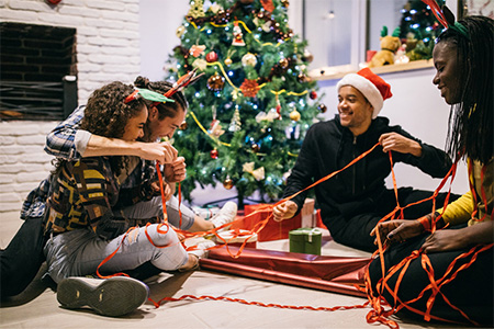 Grupp vänner som slår in julklappar