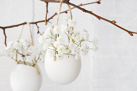 Äggskal med vita blommor som hänger i påskris