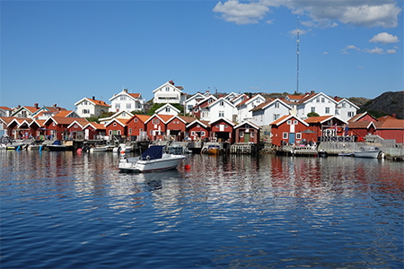 Fiskesamhälle på Orust med röda sjöbodar och vita trävillor