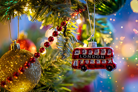 En liten julgransdekoration i form av en röd buss med texten London på sidan