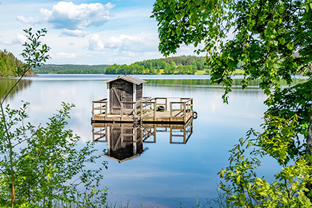 En litenbastuflotte på en spegelblank sjö