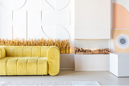 En gul soffa med runda former på armstöd och ryggstöd