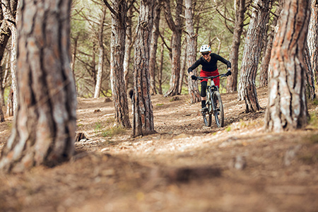 En kvinna cyklar mountainbike nedför en sluttning