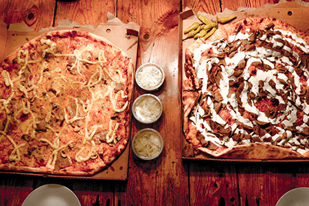 Två klassiska svenska pizzor i kartonger på ett bord