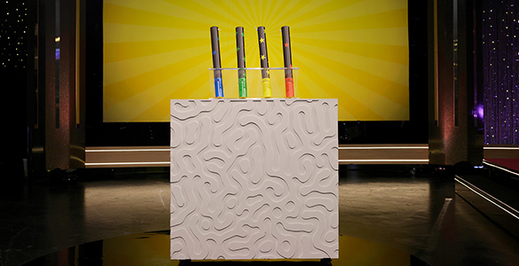 Konfettispelet i Bingolotto. Fyra rör i blått, grönt, gult och rött sticker upp ur en stor vit låda. 