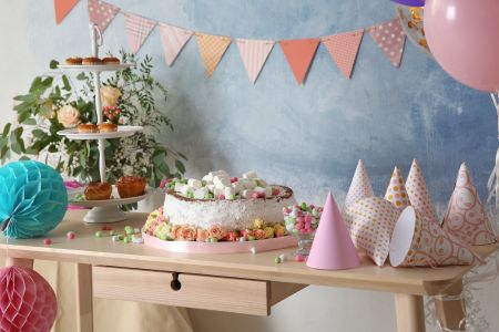 Ett bord festligt dekorerat med tårta, partyhattar och blommor